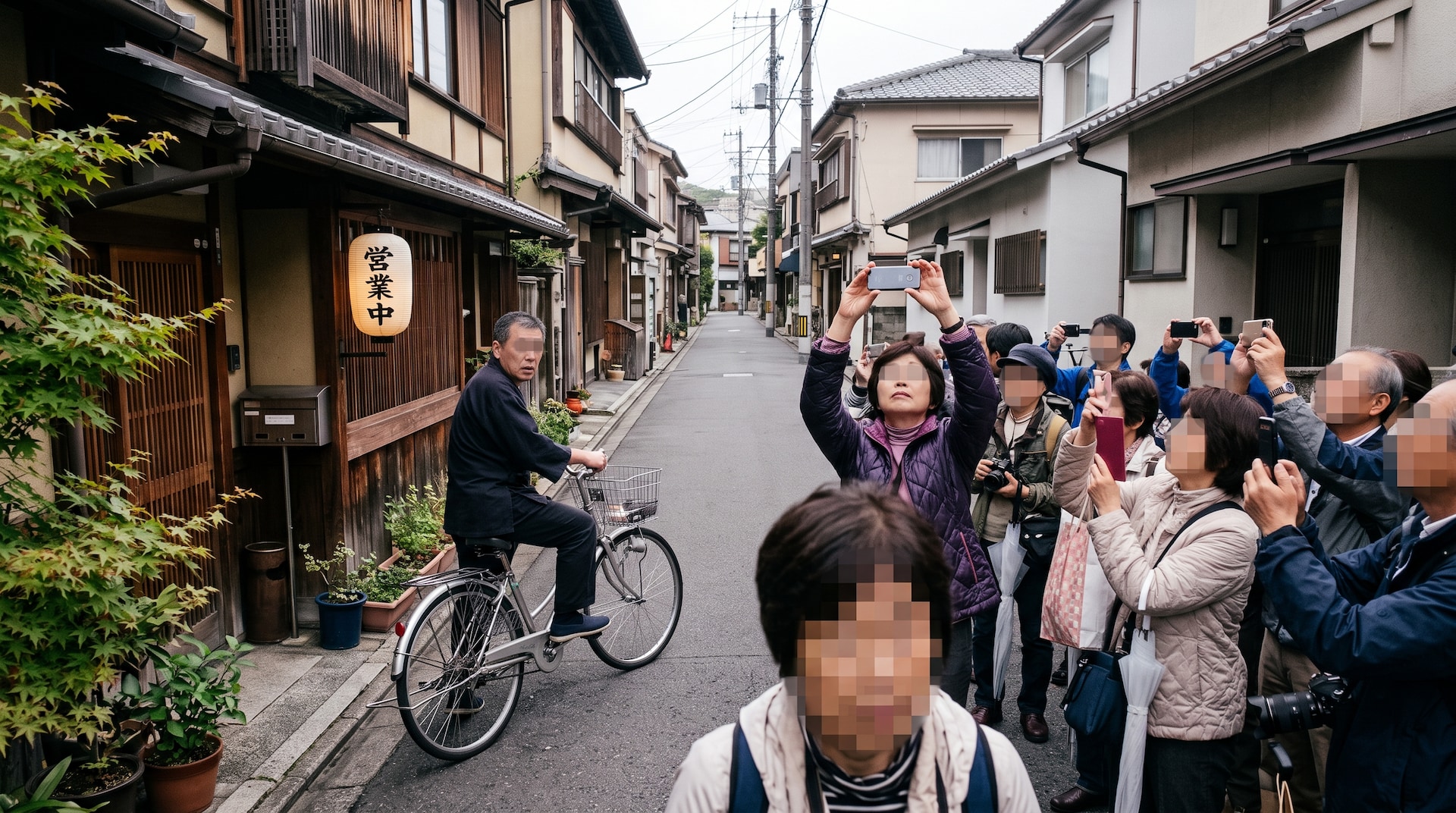 京都の伝統的な町並みで、自転車に乗る男性とスマートフォンを掲げる観光客。