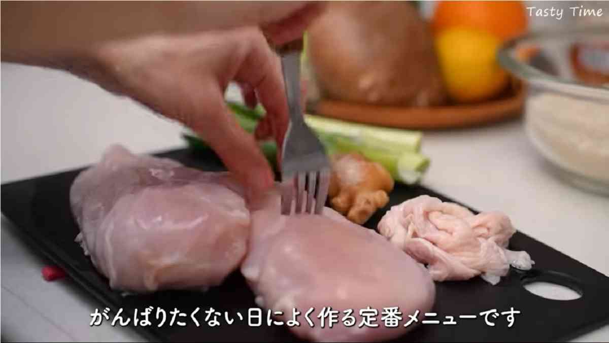 カオマンガイを作っている。鶏肉にフォークを刺して下味をつけている