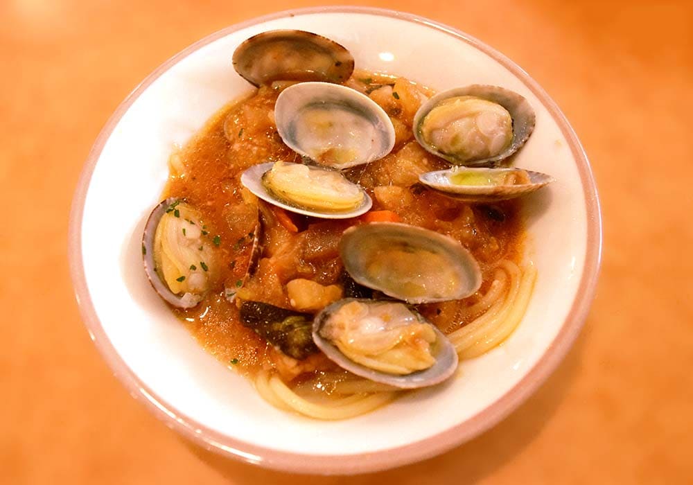 「スープ入り塩味ボンゴレ」に「田舎風ミネストローネ」を加えて混ぜ合わせ、仕上げに、お好みで無料のオリーブオイルとブラックペッパーを適量かければ完成