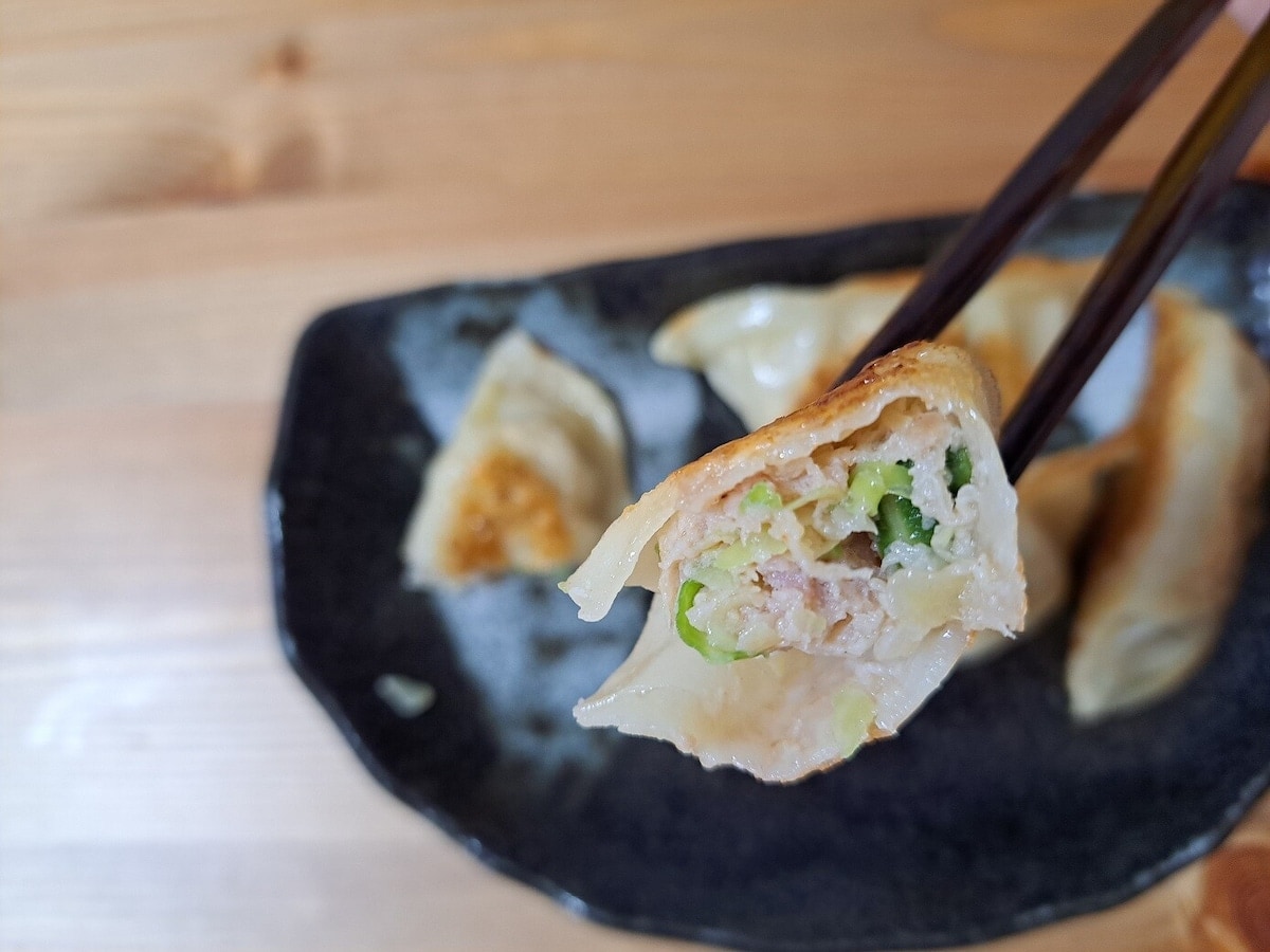 餃子の王将の焼き餃子を箸で持ち上げている画像