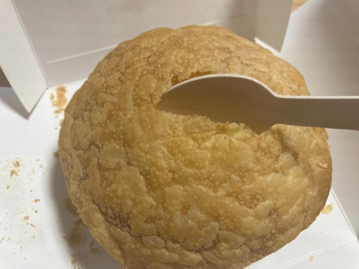 ケンタッキーの「チキンクリームポットパイ」の生地にスプーンを入れている画像