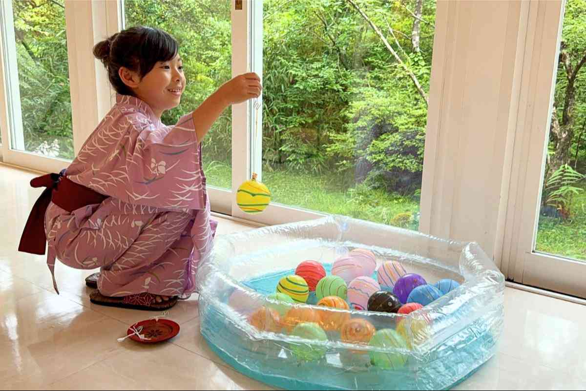 ヨーヨーを吊り上げる浴衣姿の子ども