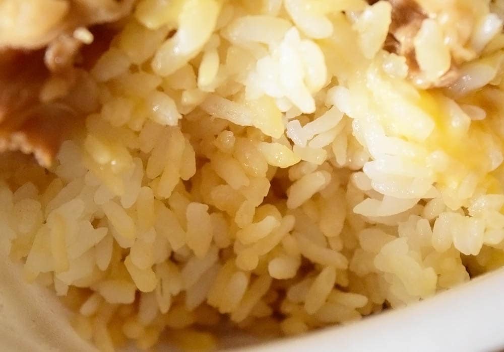 つゆの量を指定をしていない普通の牛丼は、上記写真のようにご飯の表面以外の部分にもつゆが染み込んでいます。