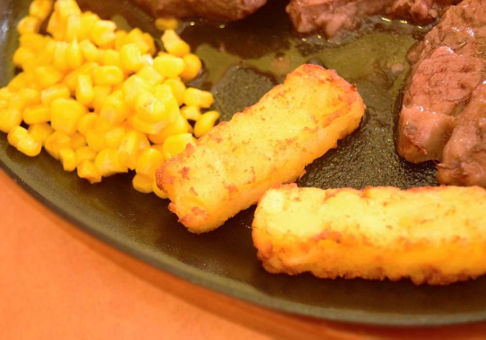 ステーキの付け合わせとして、ポテトのグリルとコーンも鉄板の上にのっています。