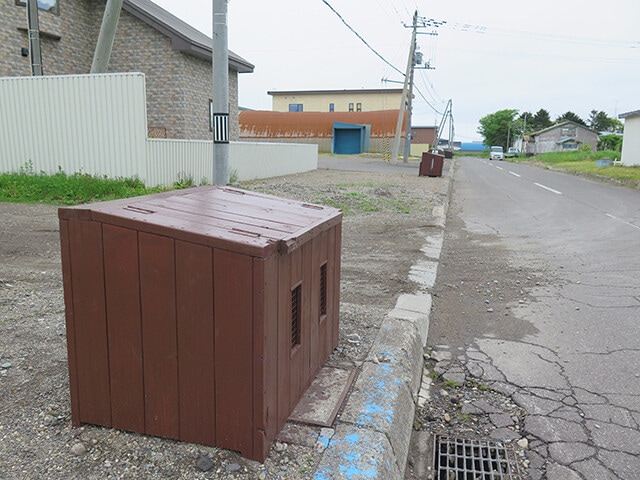 標津町の民家の門前に並ぶダストボックス。ゴミ袋をそのまま置くと餌づけ=クマの定着につながるので備えつけている家が多いのだという