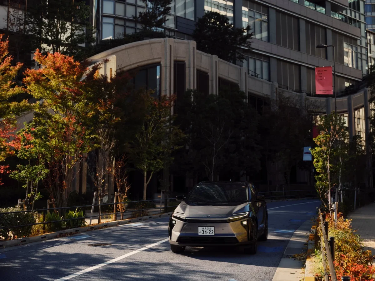 秋の都市風景の中、道路に駐車されたTOYOTA bZ4X