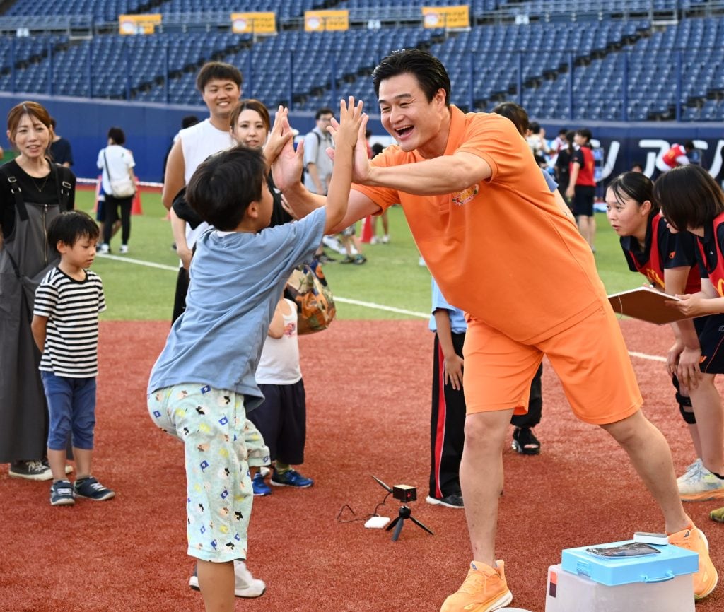 参加者とハイタッチする高岸さん（15日、ハードオフ新潟＝松﨑航大）