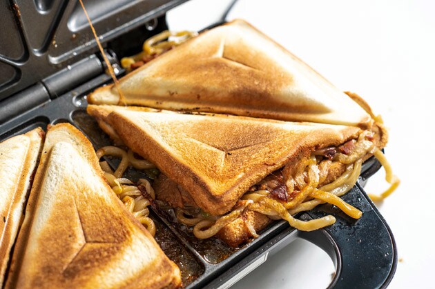 （３）完成！　５分ほどしたらホットサンドメーカーのフタを開け、中心から半分にカットすれば完成。無理やりフタの中に押し込んだのに、見事にホットサンドとして焼き上がるのはすごい！