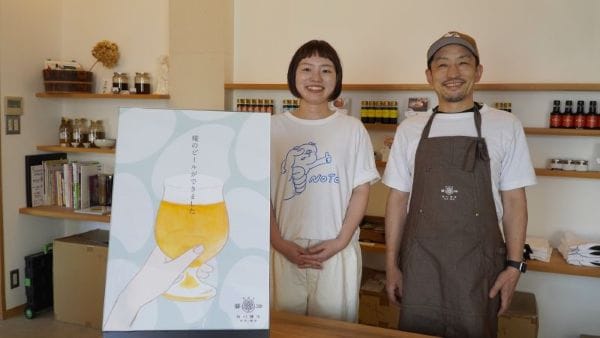 麹のクラフトビールをアイテムに加えた谷川醸造の谷川貴昭さん(右)と千穂さん=7月31日、輪島市