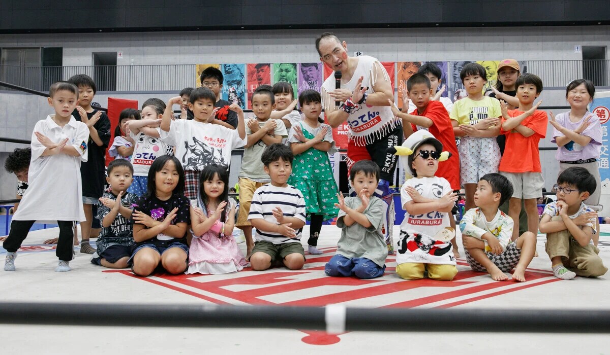リングを体験して笑顔の子供たちとばってん×ぶらぶら選手（中央）。未来のチャンピオンがここから生まれるかも？