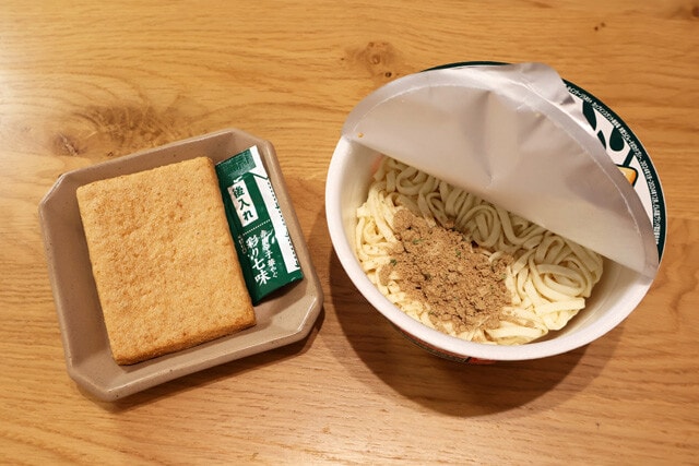 （１）開封！　どん兵衛きつねうどん（東日本版）を開封し、お揚げを取り除いたら粉末スープを入れる。余ったお揚げはそのまま食べても、いなりずしにしても、うどんに足してもOK！