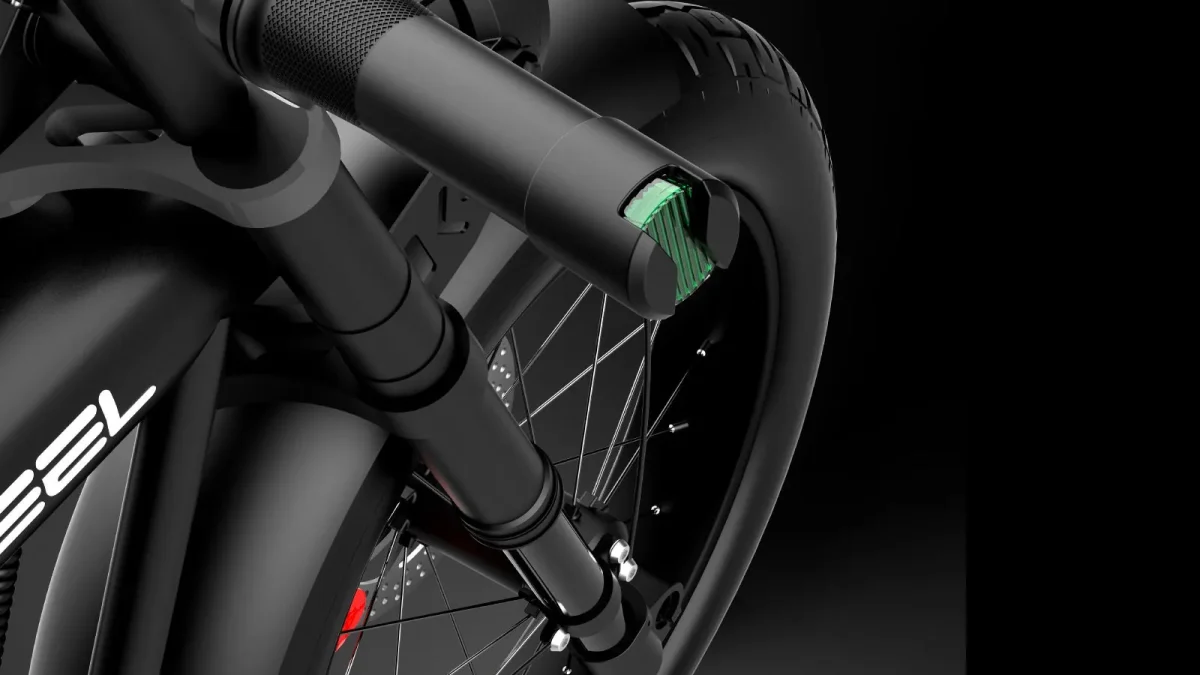 黒い自転車の前輪とサスペンションのクローズアップ。フォーク部分には緑色のライトが光る。
