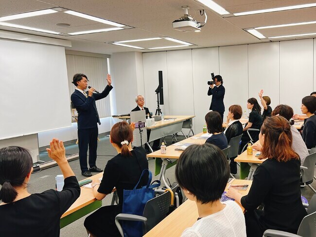 △土岐氏の問いかけに挙手で答える参加者 △土岐氏の問いかけに挙手で答える参加者