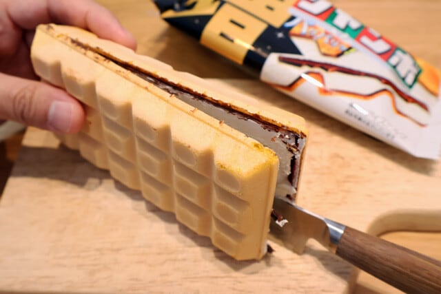 （１）開く！　チョコモナカジャンボの合わせ目に包丁やステーキナイフなどを入れ、真っぷたつに開こう。モナカ部分はとても繊細なのですぐパキッと割れてしまう。焦らず丁寧に開くこと