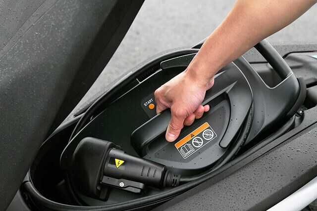 シートを開けると、容量２３リットルの収納スペースがあり、ポータブル充電器がスッポリと入る。コイツを使うと、残量ゼロから１４時間で満充電が可能だ