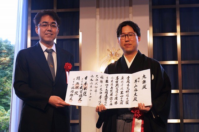 「成長した姿を見せ頑張りたい」　4連覇達成、井山碁聖の就位式開催 允許状を掲げる井山碁聖（右）と武宮理事長