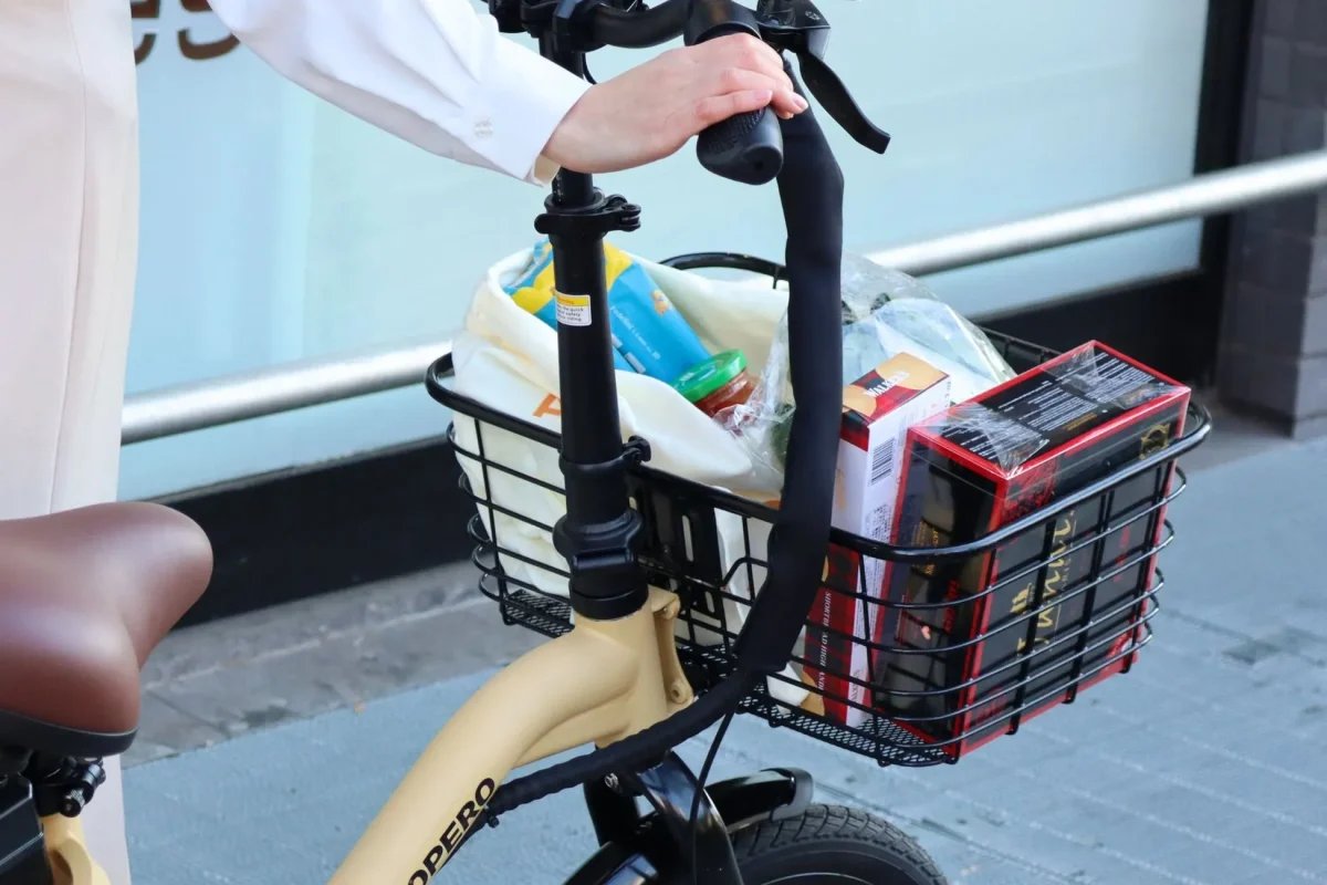 カゴに食料品を入れた自転車に乗る人