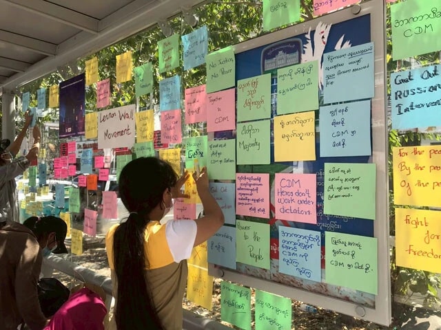 大学生たちが、バス停に「自由のために闘おう」など書かれたメッセージを貼っている。非暴力運動のひとつ(撮影:西方ちひろ)