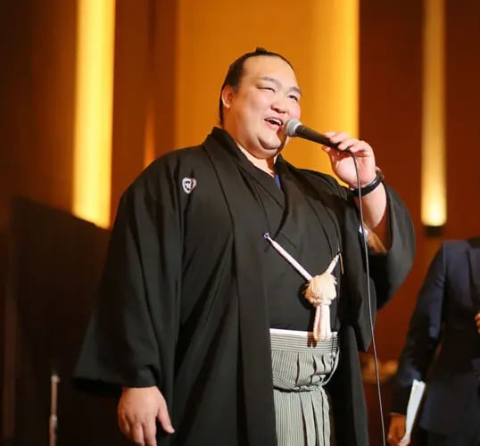 松田と二所ノ関部屋とのつながりは、現・二所ノ関親方（元・横綱稀勢の里）の現役時代にさかのぼる。写真は2017年、松田の結婚式で親方がスピーチをしたときのもの。直前の一月場所で優勝し、「新横綱」として会場に駆けつけた