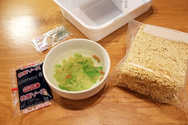 (1)かやく! ペヤングを開封して中身を全部取り出し、麺はジップロックなどに移して保存する。かやくは小皿に移して熱湯を注いで戻し、ソースの小袋もできれば熱湯で温めておこう