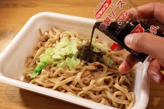 (3)仕上げ! ペヤングの容器に麺を入れたらかやくも水気を切ってから追加し、ソース、スパイス、ふりかけをよく混ぜれば出来上がり。ワシワシ食感のペヤングがこんなにウマいとは!