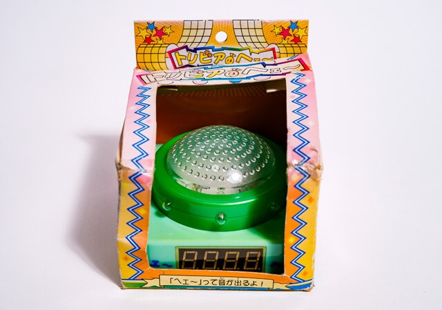 クレーンゲームの景品だった類似品「トリビアのヘェ～」。数字が4桁ある。100円ショップで販売されていた、スイッチ型の小型照明を流用したと思われる