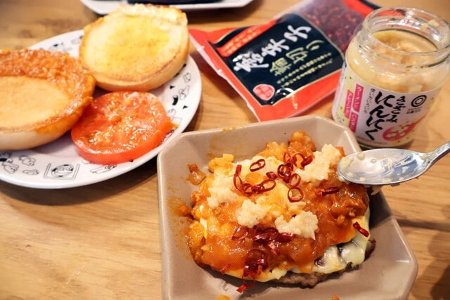 (3)味変! モスチーズバーガーのバンズを外し、トマトソースの上に刻みにんにくと輪切り唐辛子を適量のせてアラビアータ風にアレンジ! バンズは使わないので後で食べよう