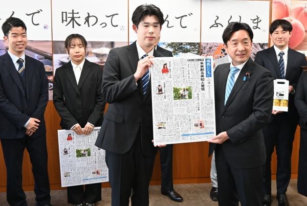 福島の現状、日英版「震災復興新聞」で世界に　神田外語大生が復興副大臣に贈呈 瀬戸隆一復興副大臣（右から2人目）に震災復興新聞のパネルを手渡す関口椋久さん（中央）ら神田外語大生