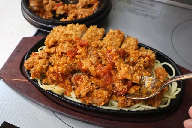 （４）仕上げ！　鉄板を加熱し、スパゲティがパチパチと音を立て始めたら（１）で作ったミートソースを全体にかければ完成。ワイルドすぎて少し食べにくいがウマさはガチ！ ご賞味あれ！