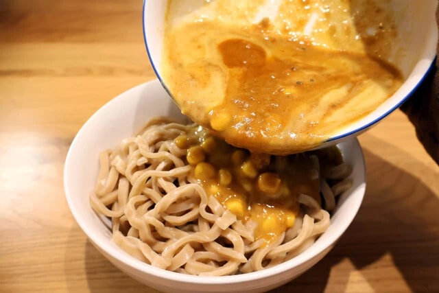 （３）仕上げ！　麺を丼に移したら（２）を全量ぶっかけ、アツアツのうちにチーズをかけて熱でとろけさせる。あとは煮卵をのせ、お好みでプリングルズを添えたら完成。手際よく盛りつけよう