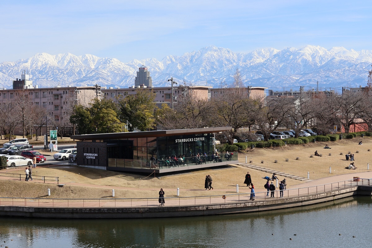 市内から望む立山連峰は絶景。中心部は路面電車の市電が走る。富山城や「世界一美しいスタバ」と称される環水公園のスターバックスなども有名な観光地だ