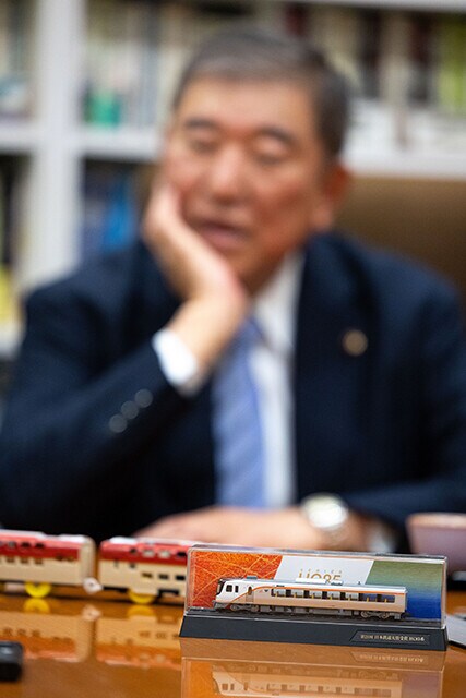 サンライズ出雲のプラレールや、ハイブリッド車両のHC85系(手前)の模型を眺めながら鉄道トークをする石破さん