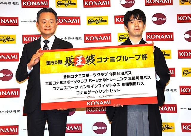 藤井七冠の棋王3連覇を祝福 都内で節目の第50期就位式 藤井聡太七冠(右)に副賞を贈る東尾公彦・コナミグループ社長