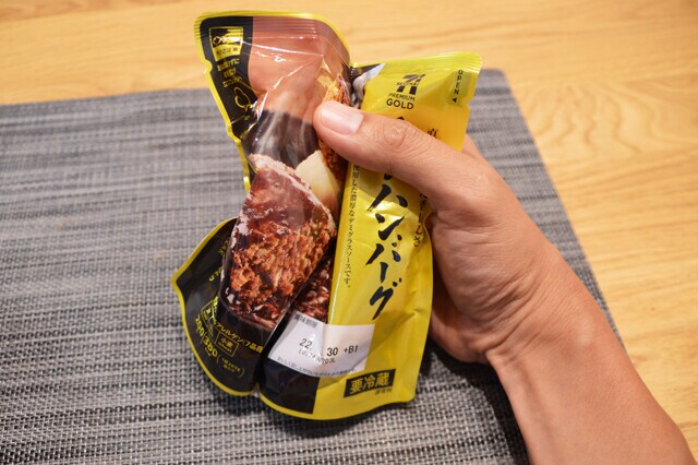 とみ田つけめんを解凍したら、温めた金のハンバーグを袋の上からほぐしてかける。黒こしょうを振り、つけ汁に浸して食べるのも絶品!