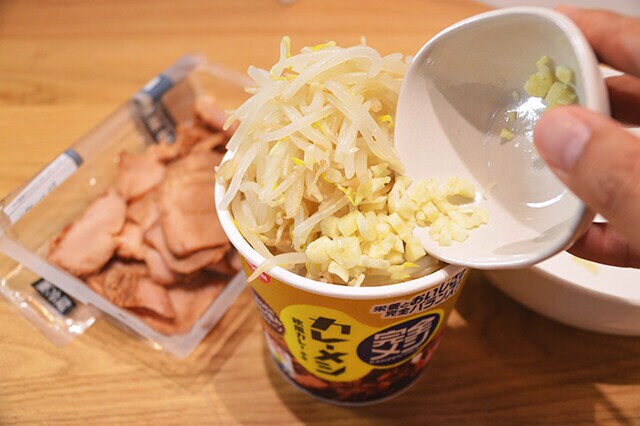 （４）盛りつけ！　あとはあらかじめ刻んでおいたニンニク、（１）のモヤシ、焼豚を山のように盛りつければ完成。焼豚より角煮のほうが二郎っぽくなるが、栄養面を考えると焼豚のほうがヘルシーだ