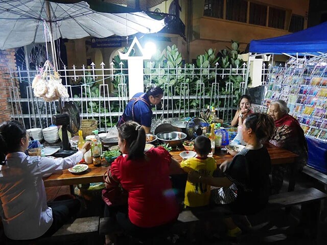 現地人と旅人がナイトマーケットで屋台メシを楽しむ様子