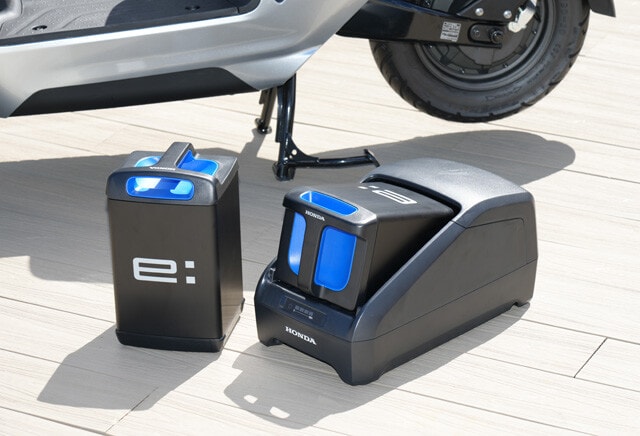 左がバッテリー。重さは10㎏程度。右が充電器。ちなみにバッテリーは国内の二輪車メーカー（カワサキ、スズキ、ヤマハ）と規格を統一