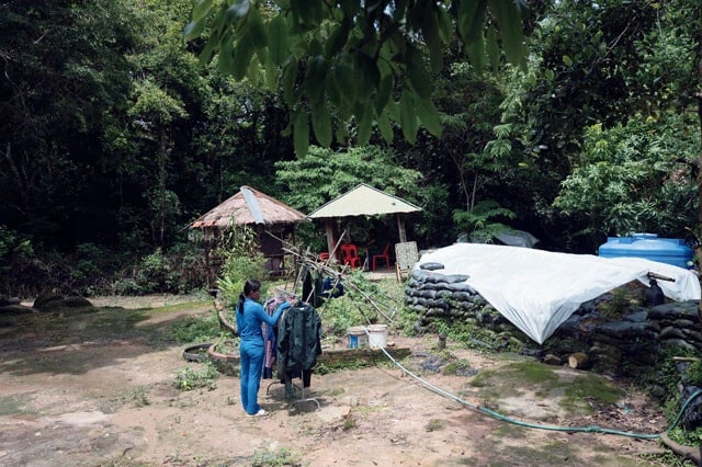 プレアビヒア寺院周辺、緊張の最前線に派遣されたカンボジア軍兵士に家族も同行。洗濯物を干す女性の前には塹壕（ざんごう）が見える