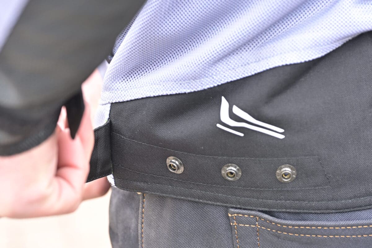 裾には３段階のアジャスターを装備。ボタン上部にはリフレクターもレイアウト。