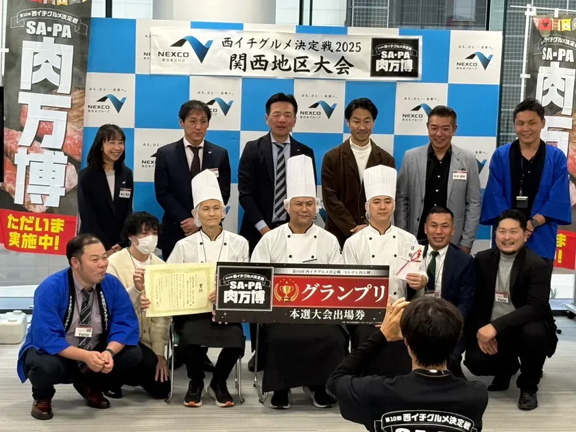 西イチグルメ決定戦2025 関西地区大会の表彰式の様子。グランプリ受賞者と関係者たちが一緒に写っています。