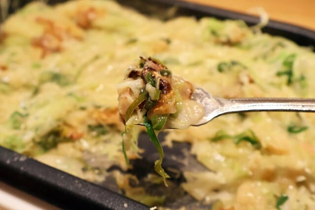 （５）食べる！　生地を伸ばしたり鉄板に押しつけたりしながら焦げ目を作り、ヘラで削り取るようにして食べよう。スパイシーな味と薬味の刺激＆食感がベストマッチの新感覚もんじゃ焼きだ！