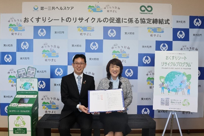薬の包装シートをペンやベンチなどにアップサイクル　第一三共ヘルスケアとテラサイクルジャパンの取り組み、東京・東大和市でも （左から）第一三共ヘルスケア　サステナビリティ推進マネジャー 岩城純也氏、東大和市 和地仁美 市長。ベンチはおくすりシートのリサイクル品