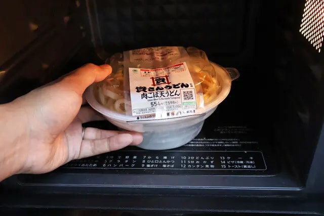 （２）レンチン！　麺をゆでている間にファミマの「資さんうどん監修 肉ごぼ天うどん」を電子レンジで調理する。手順どおり温めたらだしはそのままで麺は取り出しておこう
