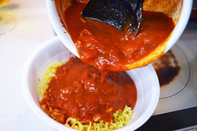 （３）かける！　トマトがグツグツと煮立ったら辛辛魚のかやく入りスープと液体スープを混ぜ、麺をカップに戻したらスープをかける。仕上げに後入れ粉末スープをかけたら完成！